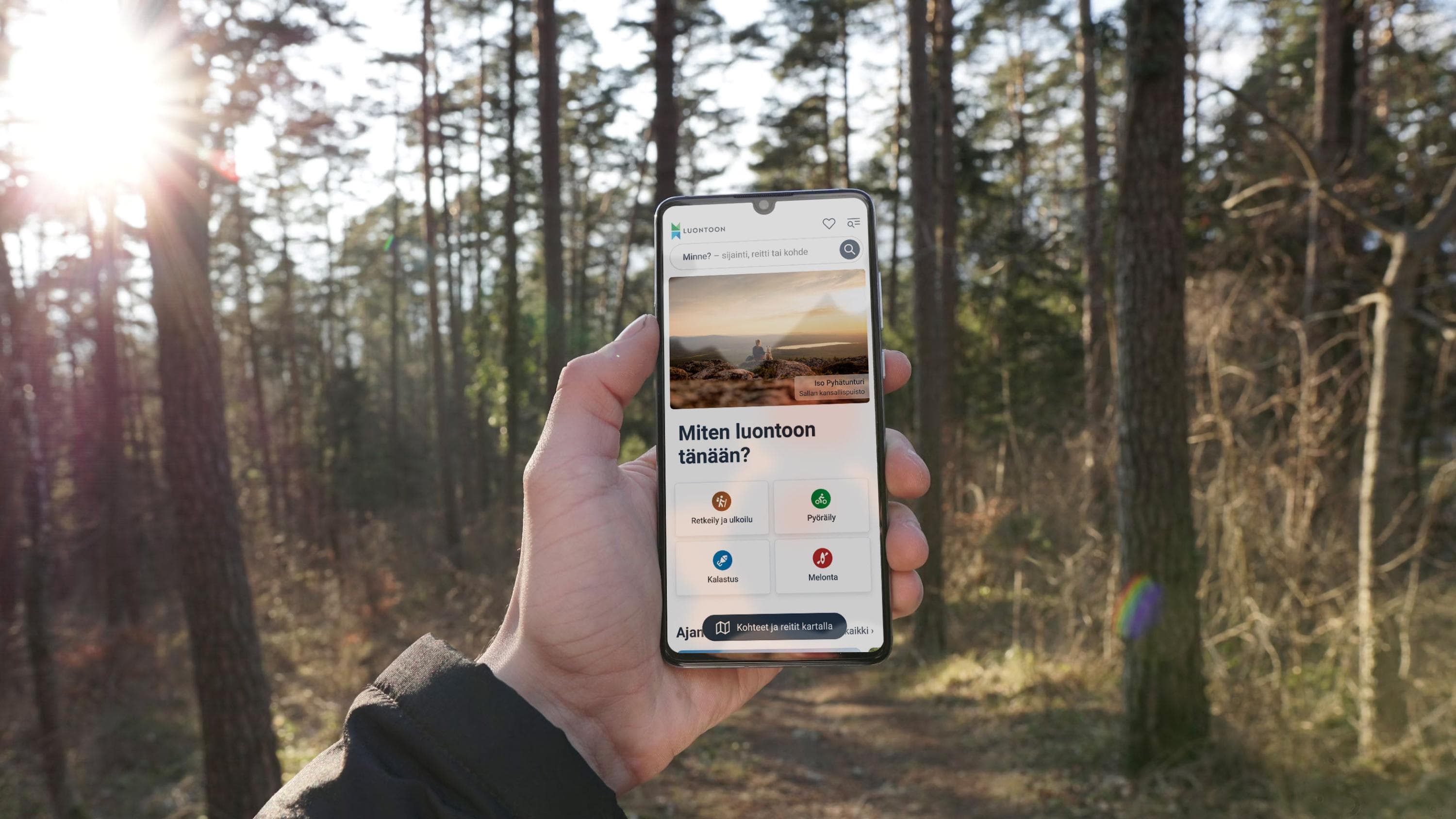 Kädessä olevassa kännykässä näkyy Luontoon-palvelu.